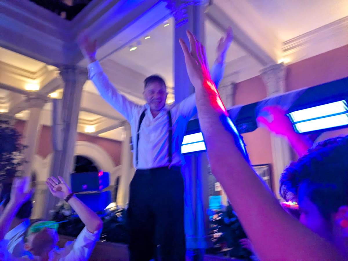 Performer with arms raised as the crowd reaches toward the stage