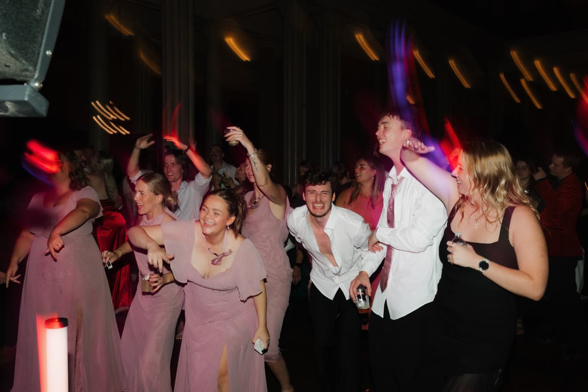 Dance floor packed with guests under colorful motion lights
